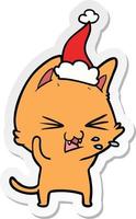 desenho de adesivo de um gato assobiando usando chapéu de papai noel vetor