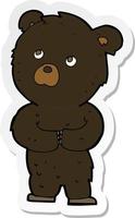 adesivo de um filhote de urso preto de desenho animado vetor