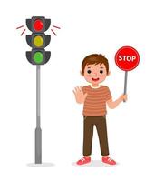 menino bonitinho segurando a placa de sinal de stop mostrando a luz vermelha do indicador de semáforo acesa vetor