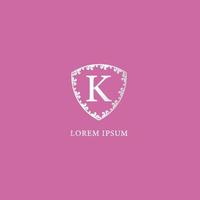 modelo de design de logotipo inicial de letra k. isolado no fundo de cor rosa. ilustração de escudo floral decorativo de luxo prata. adequado para produtos de seguros, moda e beleza. vetor