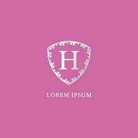 h carta modelo de design de logotipo inicial isolado no fundo de cor rosa. ilustração de escudo floral decorativo de luxo prata. adequado para produtos de seguros, moda e beleza. vetor