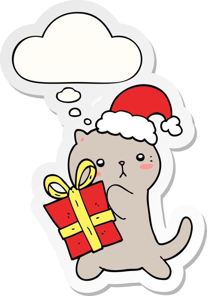 simpatico gatto cartone animato che trasporta regalo di Natale e bolla di pensiero come adesivo stampato vettore