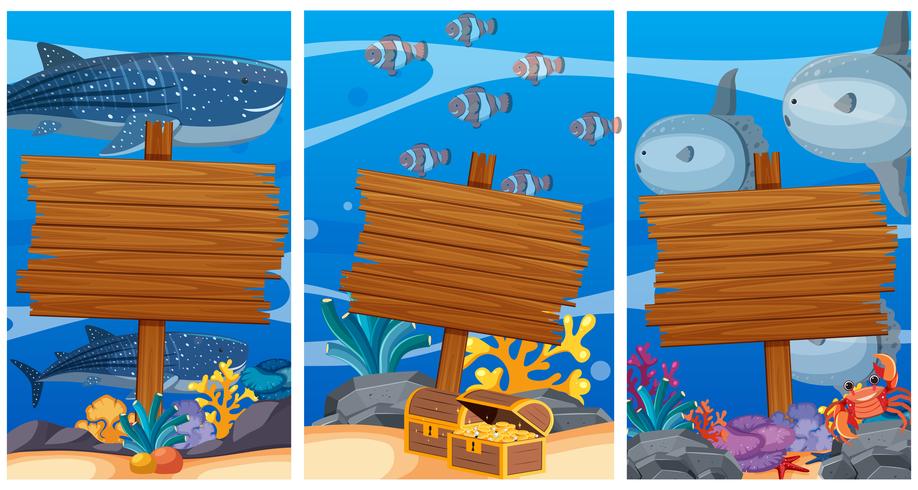 Segni di legno sotto l&#39;oceano con animali marini in background vettore