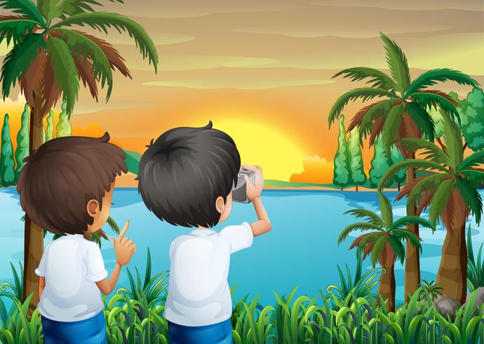 Due bambini con una macchina fotografica sulla riva del fiume vettore