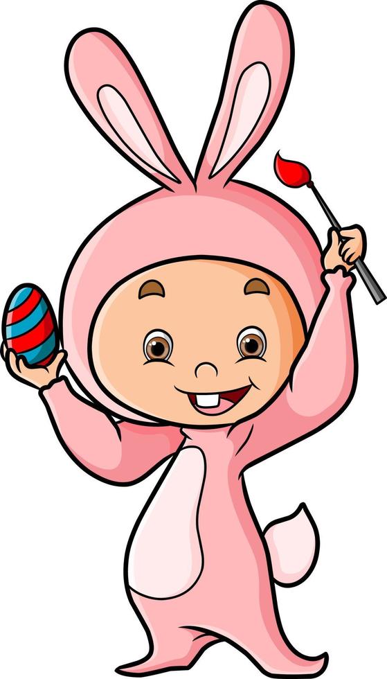 il bambino con il costume da coniglio sta dipingendo l'uovo di Pasqua vettore