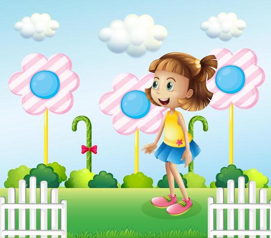Una bambina vicino al recinto di legno con caramelle giganti vettore