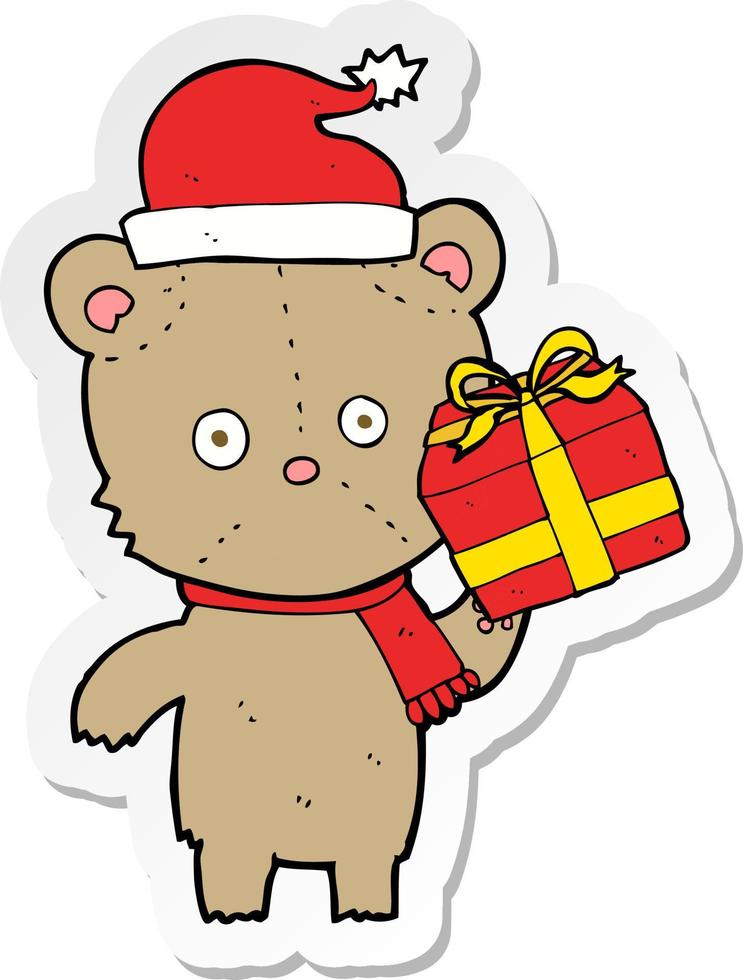 adesivo di un orsacchiotto di natale cartone animato con regalo vettore