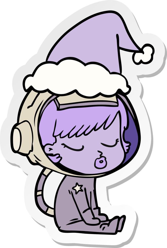 adesivo cartone animato di una bella ragazza astronauta seduta in attesa che indossa il cappello di Babbo Natale vettore