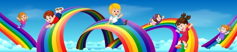 bambini dei cartoni animati che scivolano lungo l'arcobaleno vettore