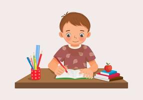 carino poco ragazzo seduta su il scrivania studiando scrittura su taccuino fare il suo compiti a casa a casa