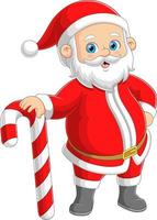 il Santa Claus è in piedi e in posa mentre Tenere un' grande caramella canna vettore