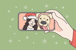 in linea Natale e nuovo anno celebrazione concetto. umano mano Tenere smartphone con sorridente ragazza e cane nel Santa cappello festeggiare e saluto in linea vettore illustrazione