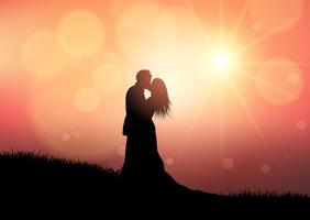 Siluetta di una coppia di cerimonia nuziale sulla priorità bassa di tramonto