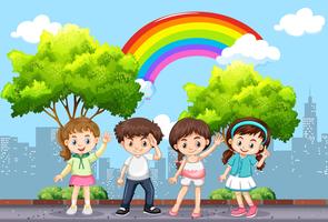 Bambini felici nel parco con arcobaleno nel cielo vettore