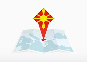 nord macedonia è raffigurato su un' piegato carta carta geografica e appuntato Posizione marcatore con bandiera di nord macedonia. vettore