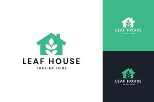 design del logo dello spazio negativo della casa delle foglie vettore