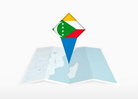 comore è raffigurato su un' piegato carta carta geografica e appuntato Posizione marcatore con bandiera di Comore. vettore