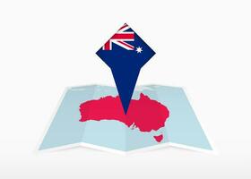Australia è raffigurato su un' piegato carta carta geografica e appuntato Posizione marcatore con bandiera di Australia. vettore