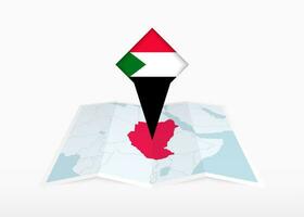 Sudan è raffigurato su un' piegato carta carta geografica e appuntato Posizione marcatore con bandiera di Sudan. vettore