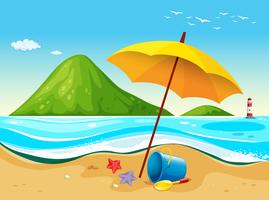 Scena della spiaggia con ombrellone e giocattoli vettore