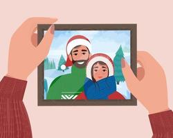 mani che tengono il ritratto di famiglia di Natale in cornice. foto per ricordo. simpatica illustrazione vettoriale in stile piatto