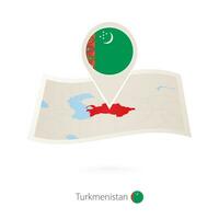 piegato carta carta geografica di turkmenistan con bandiera perno di turkmeno. vettore
