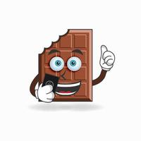 personaggio mascotte di cioccolato che tiene un cellulare. illustrazione vettoriale