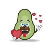 personaggio mascotte avocado con in mano un'icona d'amore. illustrazione vettoriale