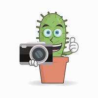 personaggio mascotte del cactus che tiene la macchina fotografica. illustrazione vettoriale