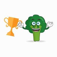 personaggio mascotte broccoli con un trofeo nella mano destra. illustrazione vettoriale