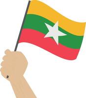 mano Tenere e raccolta il nazionale bandiera di Myanmar vettore