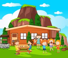 Scena con bambini che fanno un picnic vicino al cottage vettore