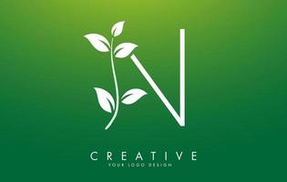 foglia bianca lettera n logo design con foglie su un ramo e sfondo verde. lettera n con il concetto di natura. vettore