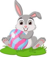 piccolo coniglio del fumetto che tiene l'uovo di Pasqua nell'erba vettore