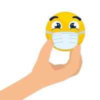 mano con, emoji che indossa una maschera medica, faccia gialla con l'icona della maschera chirurgica bianca vettore