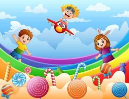 bambini felici che giocano su un'illustrazione della terra delle caramelle vettore