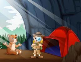 il ragazzo safari e un orso bruno nella grotta vettore