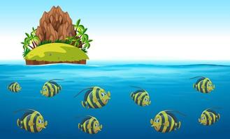 Scena con pesci che nuotano sotto il mare con l&#39;isola in alto vettore