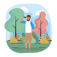 Giovane uomo urbano con la barba con lo smartphone nel parco vettore