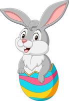 il coniglietto dei cartoni animati esce da un uovo di Pasqua vettore