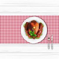 uccello di tacchino arrosto sul piatto bianco con forchetta e coltello sul tavolo di legno bianco vettore