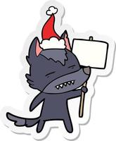 adesivo cartone animato di un lupo con cartello che mostra i denti che indossano il cappello di Babbo Natale vettore