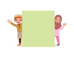 carino bambini musulmani ragazzino e ragazza sbirciando da dietro cartellone bianco sorridente e agitando le mani che mostrano copyspace per messaggi pubblicitari e annunci vettore