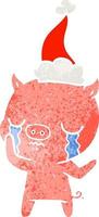 cartone animato retrò di un maiale che piange indossando il cappello di Babbo Natale vettore