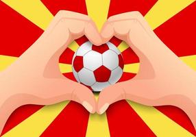 macedonia pallone da calcio e mano a forma di cuore vettore