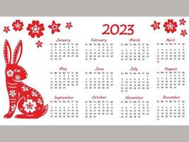 calendario 2023 con segno zodiacale, anno del coniglio, con arte tagliata su carta rossa su sfondo bianco vettore