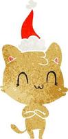 cartone animato retrò di un gatto felice che indossa il cappello di Babbo Natale vettore