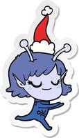 sorridente adesivo ragazza aliena cartone animato di un cappello da Babbo Natale in esecuzione vettore